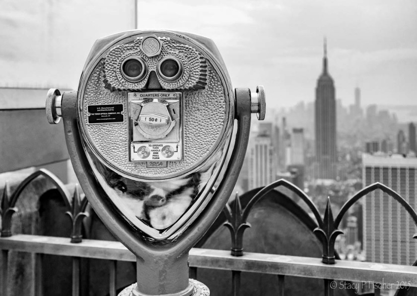 Binocular viewer atop Top of the Rock with Empire State Building in the background.