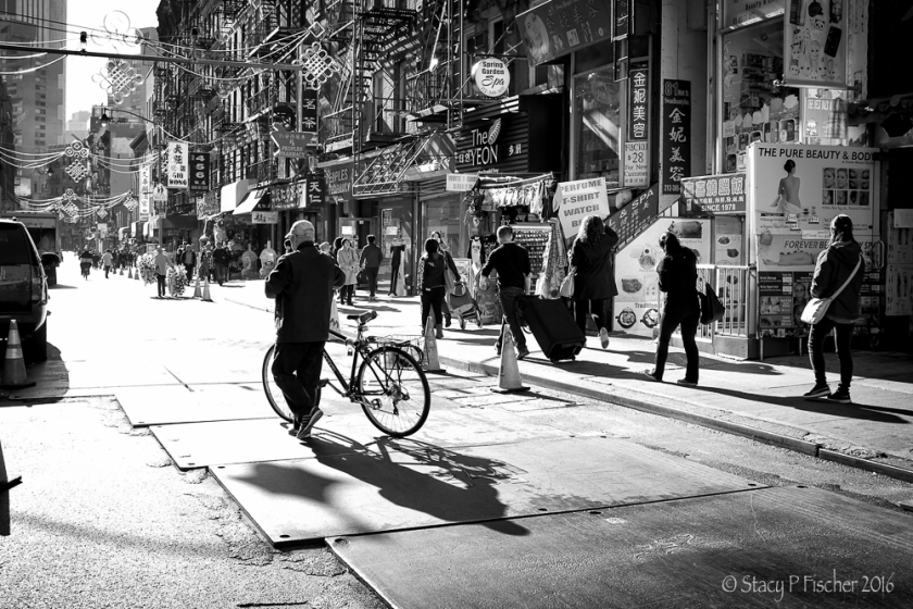Long shadows of bicyclist on Mott Street, Chinatown, New York City